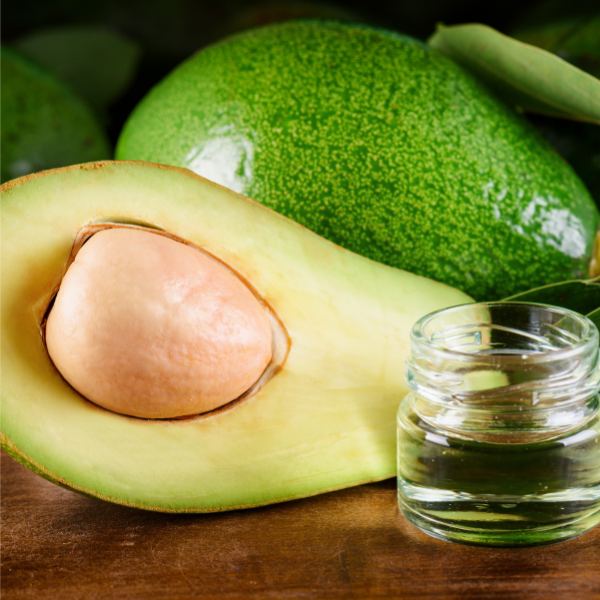 Fresh avocado with glass bottle of avocado oil, used in Evolving Textures Drip Oil Spray known for its nourishing and moisturizing benefits for hair and scalp.